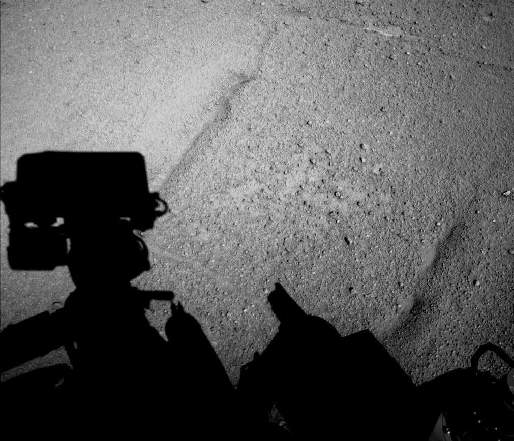 Curiosity a photographié son ombre projetée sur le sol plus lisse où il avance désormais. Image capturée par la caméra de navigation (Navcam) de gauche lors de la fin d’après-midi de son 547<sup>e</sup> jour sur Mars. Le rover venait de parcourir 100,3 mètres dans la plaine. © Nasa, JPL-Caltech