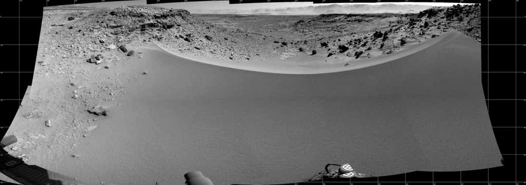 Mosaïque de 16 images capturées avec la caméra de navigation (NavCam) de Curiosity, le 30 janvier (sol 528). Le passage Dingo Gap est envisagé comme nouvelle route vers le prochain site de forage KMS-9. Les vallées de l’ouest s’étalent en contrebas de ce petit promontoire. Les dunes rocailleuses à gauche et à droite mesurent un mètre de hauteur. © Nasa, JPL, MSSS