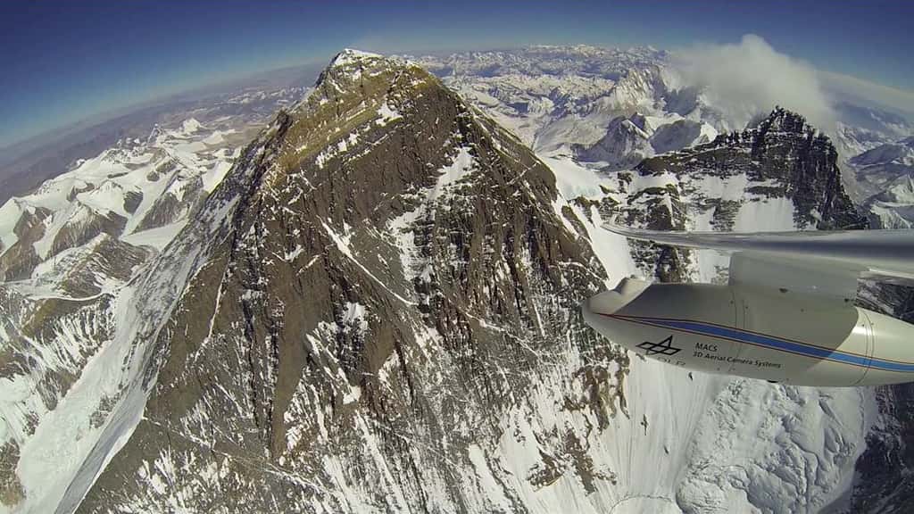 Au centre, le mont Everest, alias Chomolungma, observé depuis le motoplaneur Stemme S10-VTX, avec le Lhotse à droite (sommet à 8.516 m). Sous l'aile de l'appareil, on distingue le « pod » qui abrite le système de caméras Macs. Les images enregistrées durant le vol sont ensuite traitées sur ordinateur pour réaliser une cartographie 3D. Il s'agit ici d'une expérimentation. © Klaus Ohlmann