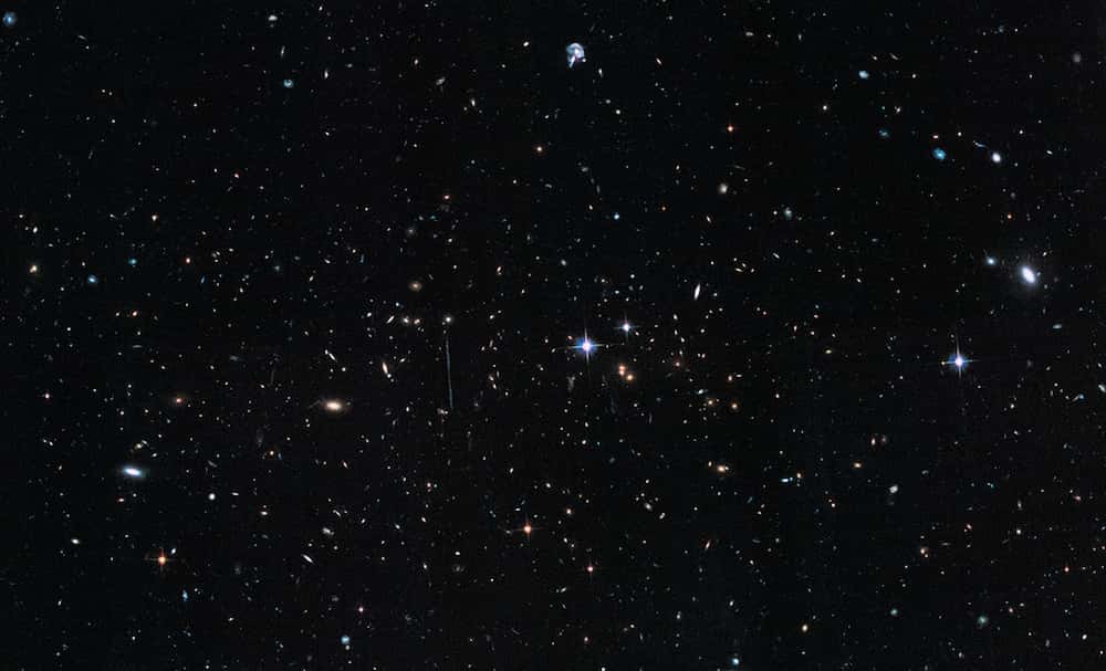Distant de 7,2 milliards d'années-lumière de nous, El Gordo regroupe plusieurs centaines de galaxies. Il s'agit de la collision de deux superamas. Sa masse totale est évaluée à 3.000 fois celle de la Voie lactée. Invisible sur ce paysage cosmique dépeint par Hubble dans le visible, d'immenses volumes de gaz chauds et de matière noire déduits par une nouvelle étude constituent l'essentiel de sa masse. © Nasa, Esa, Hubble, Chandra