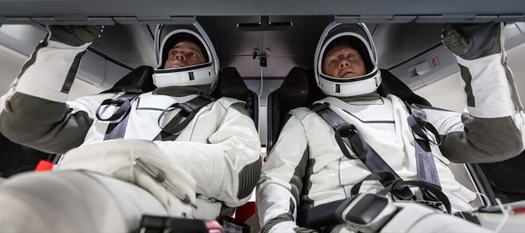 À bord du vaisseau spatial qui les transportera jusqu'à l'ISS, les astronautes de la Nasa, Doug Hurley et Bob Behnken, se familiarisent avec le Crew Dragon de SpaceX. © Nasa