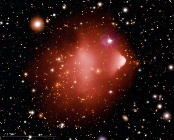 Une photo composite montrant l'amas galactique du <em>Bullet cluster</em>, situé à environ 3,8 milliards d'années-lumière de la Terre, réalisée à partir d'images de Chandra (rayons X), du télescope spatial Hubble et du télescope Magellan au Chili. © Nasa/CXC/CfA/M.Markevitch <em>et al.</em>
