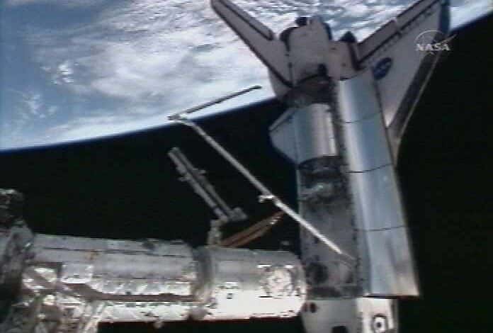 Extrait de la soute de la navette, le module Columbus va bientôt être fixé sur la Station spatiale internationale. © Nasa-TV