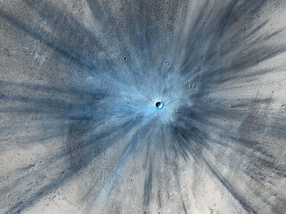 Un cratère d’environ 30 mètres de diamètre — détecté par CTX puis photographié par HiRISE en novembre 2013 —, entouré d’une zone balayée par le souffle de l’impact et des débris projetés jusqu’à 15 kilomètres de là. © Nasa, JPL-Caltech, Université de l’Arizona