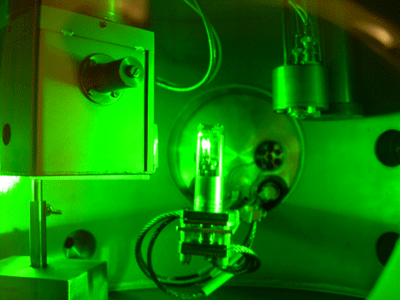Du deutérium dense est irradié par un laser. L'éclat blanc dans le récipient au centre de la photo provient du deutérium. Crédit : Leif Holmlid-Atmospheric Science, Department of Chemistry, the University of Gothenburg