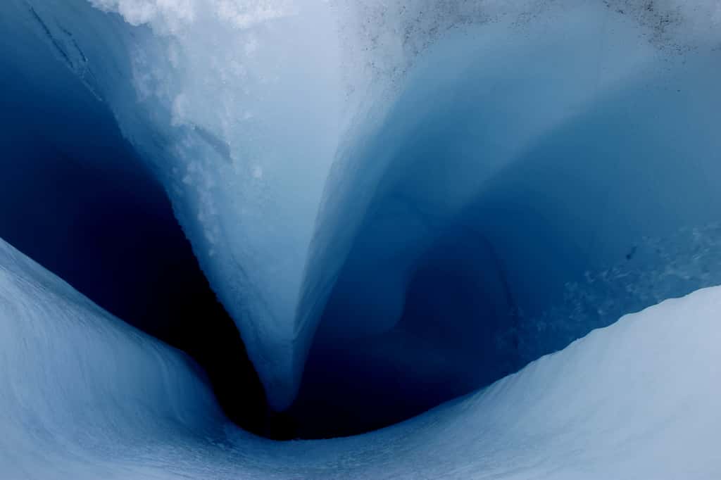 Cette photographie a été réalisée dans une région à environ 16 km de la marge de la calotte glaciaire, dans le sud-ouest du Groenland. L’eau de fonte provenant de la surface du glacier Sermeq Avannarleq pénètre dans les fissures et atteint la glace interne. L’eau s'écoulant à travers la glace réchauffe probablement la calotte glaciaire de l'intérieur et ramollit la glace, qui se déforme et peut circuler plus vite. © William Colgan, Cires