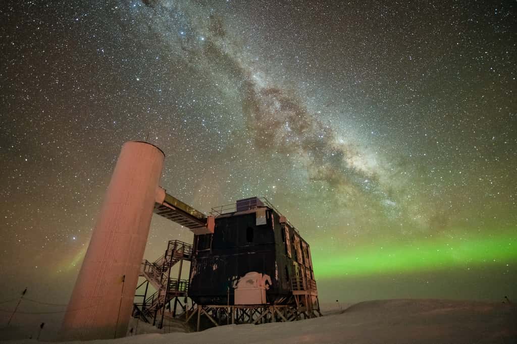 Ici, IceCube sur fond de ciel nocturne étoilé montrant la Voie lactée et des aurores australes vertes. © Yuya Makino, IceCube/NSF