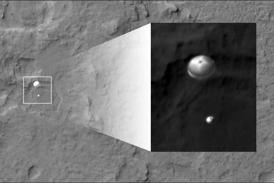 La capsule abritant le rover Curiosity et sa grue volante, lors de la descente sous parachute, saisie par l'orbiteur MRO et son instrument Hirise (<em>High-Resolution Imaging Science Experiment</em>), une minute avant l'atterrissage. © Nasa, JPL, <em>University of Arizona</em>