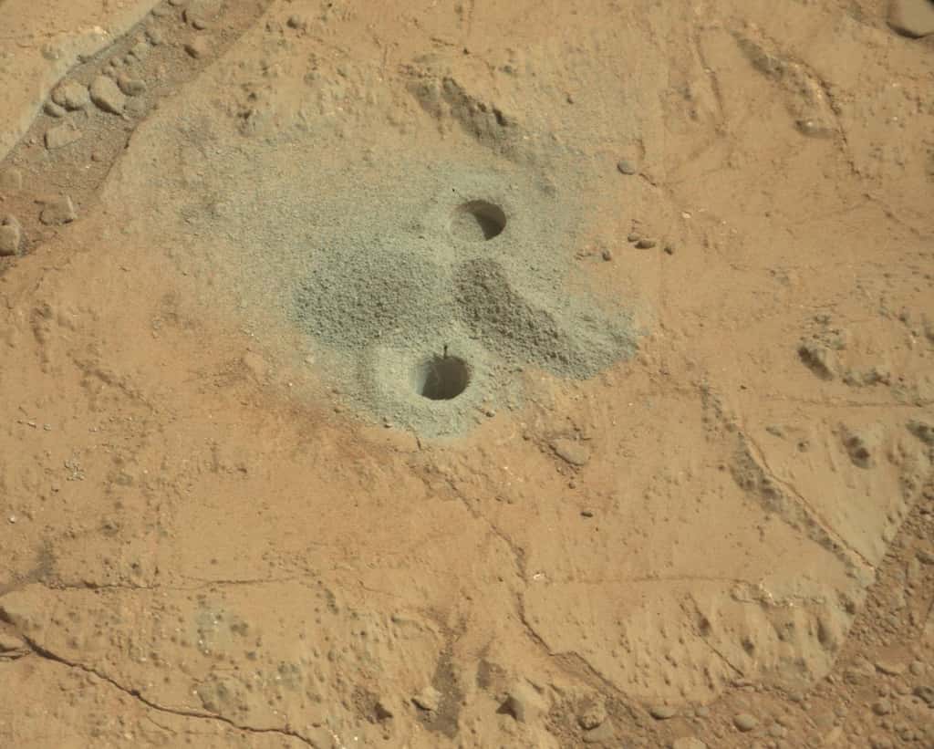Les premiers trous sur Mars. Celui du haut est un essai. Celui du bas a servi à prélever des échantillons qui doivent ensuite être envoyés dans un tamis. On voit d'ailleurs le matériau cru (petit tas à droite) et après tamisage (à gauche), une installation réalisée uniquement pour la photographie. © Nasa, JPL-Caltech, MSSS
