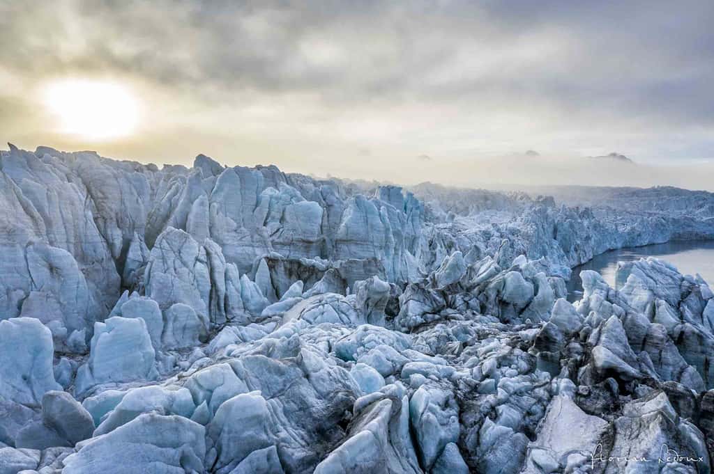 Vue au-dessus du glacier Olsokbreen dans le brouillard alors que le soleil de minuit perce. © Florian Ledoux, tous droits réservés