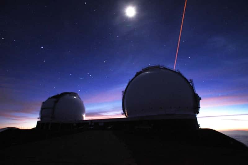 Une vue sous la Pleine Lune des deux dômes abritant les télescopes de l’observatoire W. M. Keck, à Mauna Kea (Hawaï). Ces deux instruments travaillant ensemble permettent de faire de l'interférométrie. Des faisceaux laser (l'un est visible sur la droite de l'image) sondent la turbulence de l'atmosphère pour, en temps réel, en compenser les effets par optique adaptative. © <em>Keck Observatory</em>