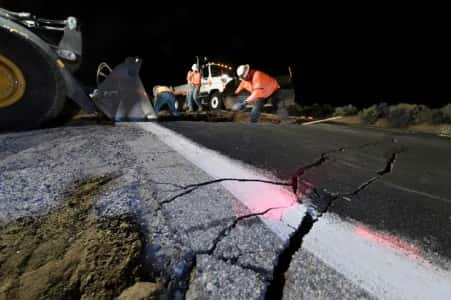 Des ouvriers comblent un trou ouvert sur une route près de Ridgecrest en Californie, après un séisme de magnitude 7,1, le plus important depuis 20 ans. © Robyn Beck, AFP