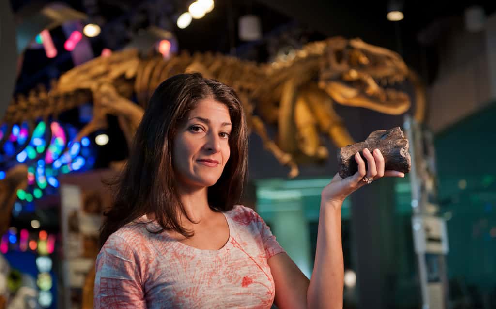 Lindsay Zanno, de l'équipe des découvreurs, expose dans sa main l'une des vertèbres de <em>Siats</em> extirpées d'une terre vieille de 98 millions d'années. © NCSU