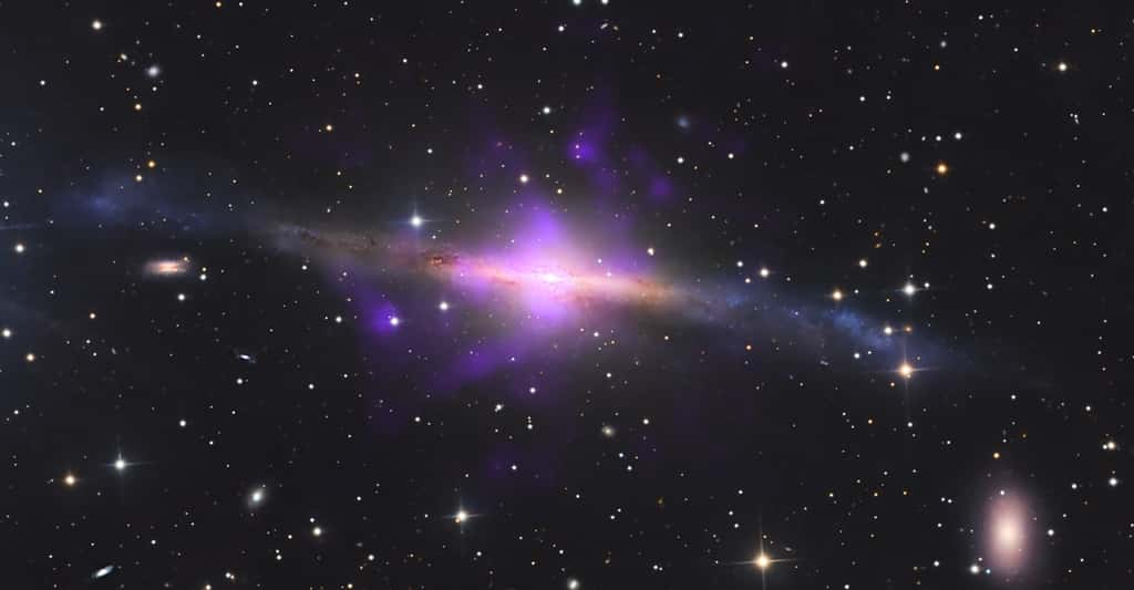 Des astronomes du Centre de recherche Ames de la Nasa ont découvert un trou noir « renversé » dans la galaxie NGC 5084. Ici, les données de l’observatoire à rayons X Chandra – en violet – sont superposées à une image en lumière visible de la galaxie. Elles révèlent quatre panaches de gaz chaud émanant d’un trou noir supermassif « renversé » au cœur de la galaxie. © X-ray : Nasa/CXC, A. S. Borlaff, P. Marcum et al. ; Optical full image : M. Pugh, B. Diaz ; Image Processing : Nasa/USRA/L. Proudfit