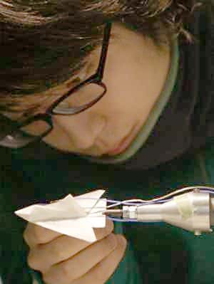Préparation d'un avion en papier pour un test en soufflerie. Crédit : Université de Tokyo.