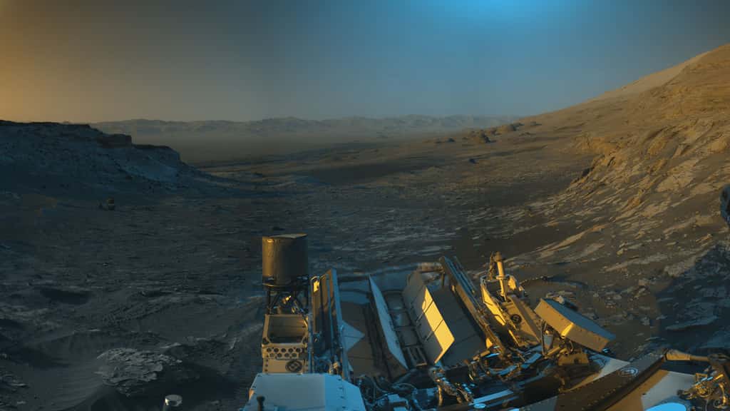 En novembre 2021, le rover Curiosity de la Nasa avait déjà utilisé ses caméras de navigation en noir et blanc pour capturer des panoramas de Mars à deux heures différentes de la journée ; la couleur bleue, orange et verte avait alors été ajoutée à une combinaison des deux panoramas pour une interprétation artistique de la scène. © Nasa, JPL-Caltech