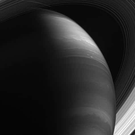 Le savoir de Saturne. Saturne offre des mystères bien plus profonds et une histoire bien plus étonnante que son homologue de l'antiquité. Ses paysages gazeux semblent se modifier au gré des observations. Ses ouragans, ses orages titanesques grondent sans répit et ses anneaux majestueux content une éternité de collisions et de cataclysmes, tandis que ses satellites recèlent peut-être les secrets des prémisses de la vie. Position de Cassini : 28° d'inclinaison sud par rapport au plan des anneaux. Image infrarouge (890 nm). Date : 30 janvier 2007. Distance : 1,1 million de km.