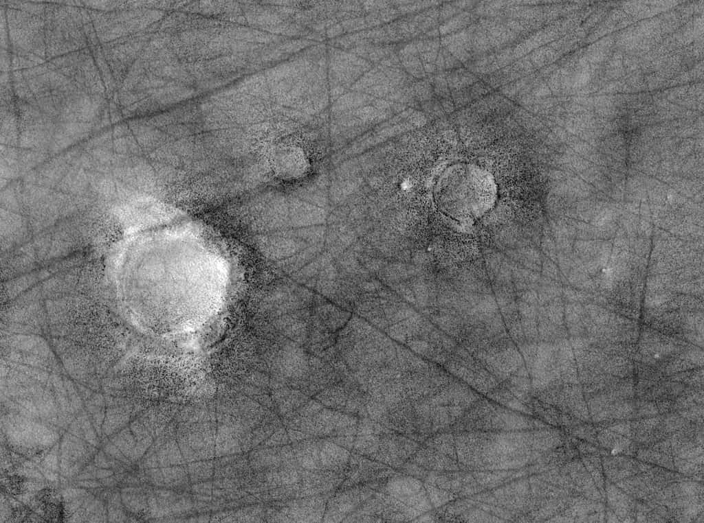 La caméra <a href="http://hirise.lpl.arizona.edu/" target="_blank">HiRise</a> a photographié cette région située au nord d'Utopia Planitia. Les rainures sombres sont de simples ondulations. On distingue une différence de nature des terrains autour des cratères d'impacts. Un traitement approprié de l'image (voir ci-dessous) révèle des champs de rochers. Crédit Nasa / JPL-Caltech / University of Arizona