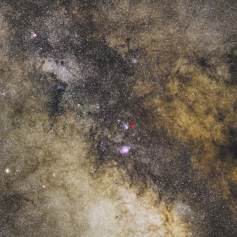 Perdue dans la Voie lactée, la Trifide (flèche rouge) n'est pas la seule nébuleuse visible sur cette spectaculaire image. Crédit Serge Brunier