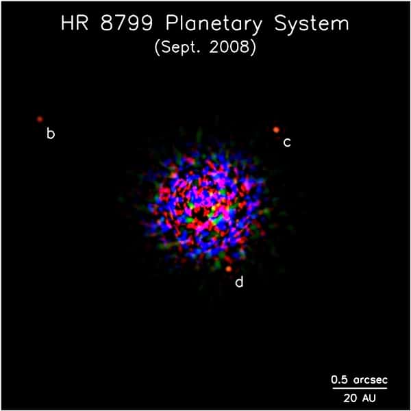 HR 8799 et ses trois exoplanètes vues par les instruments de Keck en 2008. L'image centrale de l'étoile a été soustraite par un processus de traitement de l'image pour faire apparaître les trois exoplanètes. La tache que l'on voit au centre est donc un artefact de ce traitement de l'image. © <em>Keck Observatory</em>