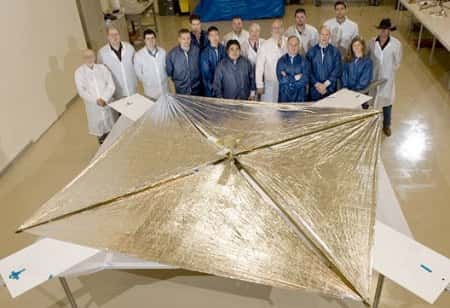 Lors d’un test de déploiement en laboratoire, l’équipe du projet pose devant NanoSail-D. © Nasa