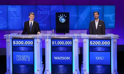 L'écran de Watson au milieu de ses deux concurrents sur le plateau du jeu télévisé Jeopardy. © IBM/Rutter Jennings