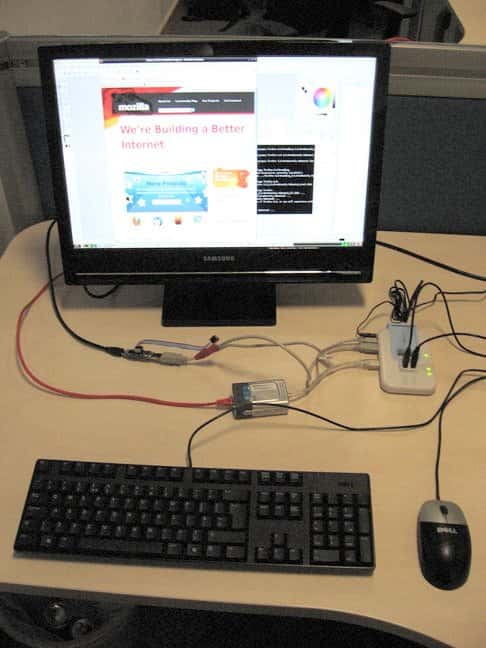 L'ordinateur, c'est la petite chose devant le pied de l'écran, un peu à gauche. Il est branché à l'écran, à une alimentation et à un <em>hub</em> USB. La mémoire de masse est une carte mémoire, SD ou MMC. © Raspberry Pi