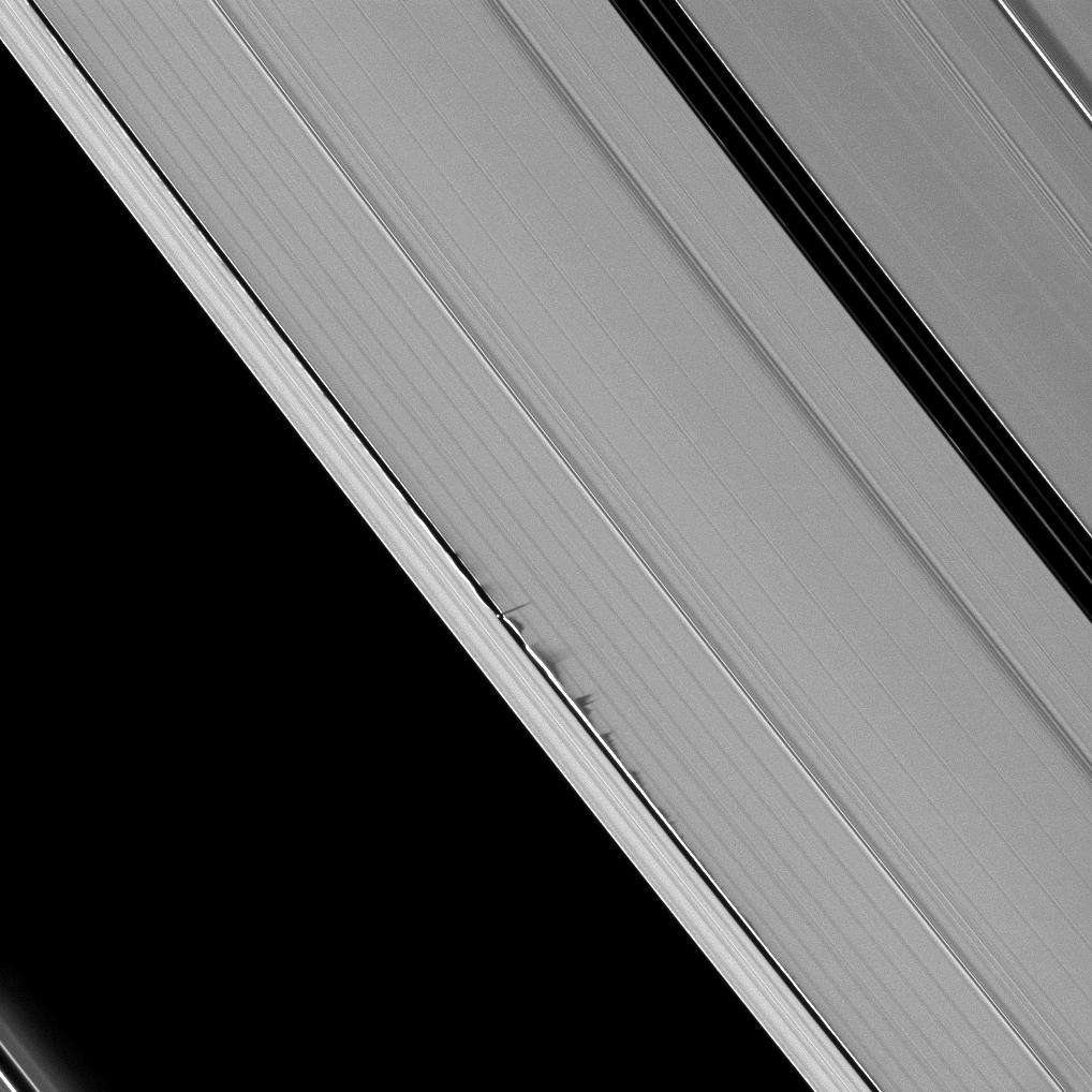 Sur cette image spectaculaire prise par la sonde Cassini, on voit des ondulations dans la structure des anneaux de Saturne, créées par le passage de la petite lune Daphnis. Les perturbations gravitationnelles ont déformé localement les anneaux en provoquant une remontée des matériaux au-dessus du plan des anneaux. On voit même l'ombre que projettent ces remontées. © N.A.S.A, JPL