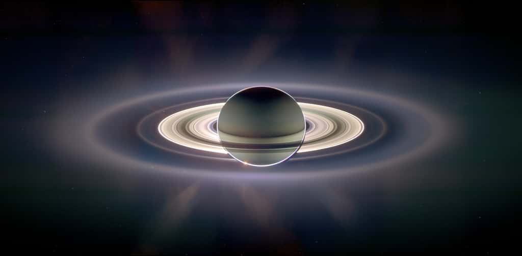 Sur cette image prise à contrejour, on voit la poussière autour de Saturne diffusant la lumière du Soleil. Surtout, en haut à gauche de la partie la plus brillante des anneaux de Saturne, on peut voir un <a title="Carl Sagan : un point bleu pâle" target="_blank" href="http://www.youtube.com/watch?v=fsXIvf_-Hz0">point bleu pâle</a> selon l'expression de Carl Sagan. C'est la Terre ! © N.A.S.A, JPL