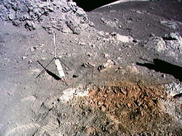 Le « sol orange » découvert par le géologue Harrison Schmitt lors de la mission Apollo 17 non loin du site d'alunissage de Taurus-Littrow. L'objet en forme de tripode est un gnomon associé à une charte photométrique qui sert de référence pour interpréter les couleurs de l'image. © Nasa