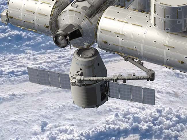 Vue d'artiste de l'amarrage de la capsule Dragon. Après une phase d'approche automatique, la capsule est saisie par le bras de l'ISS pour être dockée sur le nœud de jonction Harmony (node 2) sur lequel s'amarraient les navettes. © SpaceX