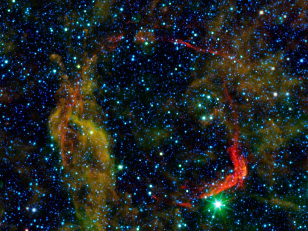 Les observations dans le domaine des infrarouges des télescopes spatiaux Spitzer et <em>Wide-field Infrared Survey Explorer</em> (Wise) sont regroupées dans cette image de RCW 86, la plus ancienne supernova (attestée par des documents) observée par l'humanité. La poussière chauffée à quelques centaines de degrés, ce qui est plus chaud que celle du milieu interstellaire, se montre clairement avec les couleurs artificielles rouge et jaune. © Nasa/JPL-Caltech/Ucla