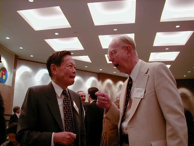 De gauche à droite, Chen Ning Yang et Robert Mills en pleine discussion à la fin des années 1990. En 1954, les deux chercheurs avaient proposé une théorie de la force nucléaire forte basée sur la notion d'invariance de jauge issue des travaux du mathématicien Hermann Weyl. Leur nom a été donné à une large classe de théories des champs proposée en physique des particules, depuis leurs travaux. Les théories des champs du Modèle standard, le modèle électrofaible de Glashow-Salam-Weinberg et la chromodynamique quantique (QCD), sont des héritières de celle de Yang-Mills. © Nu Xu