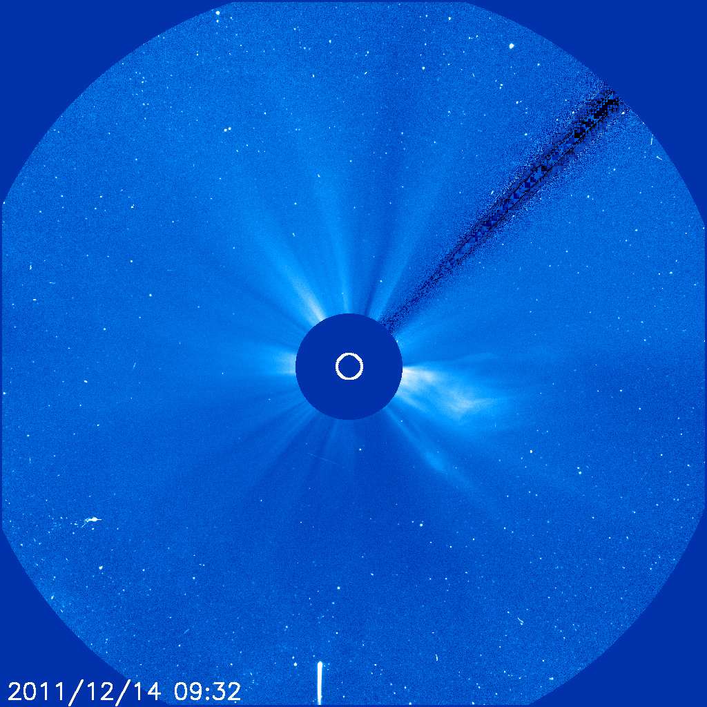 Une photo du Soleil prise derrière le <a href="http://sohowww.nascom.nasa.gov/pickoftheweek/old/03dec2011/" title="La comète suivie par Soho" target="_blank">coronographe de Soho</a> le 14 décembre 2011 à 10 h 32 en heure française : la traînée blanche en bas de l'image est la trace de la comète Lovejoy, en train de s'approcher du Soleil, qu'elle devrait raser demain à 140.000 kilomètres avant de s'en éloigner... à moins qu'elle ne sorte pas du piège ! © Soho
