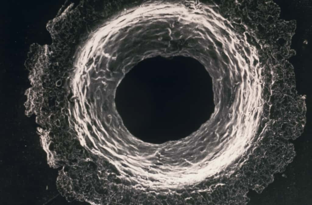Exemple d'impact de débris spatial sur un satellite. Une sphère d'aluminium d'un diamètre de 1 mm se déplaçant à une vitesse de 10 km/s perfore une paroi d'aluminium de 4 mm d'épaisseur. Un tel projectile a la même énergie cinétique qu'une boule de pétanque lancée à 100 km/h. © Cnes