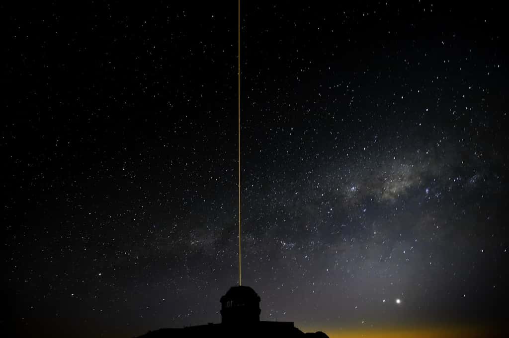 Le laser du système GeMS en action au-dessus de la coupole du télescope Gémini sud installé sur le Cerro Pachon. © <em>Gemini Observatory</em>