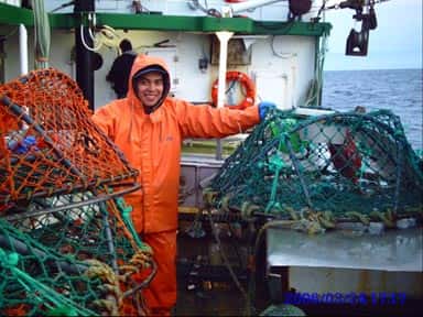 L'hydrophone se trouve dans la boule verte, sous la main gauche de Juan Espana. C'est en effet ce pêcheur qui s'est chargé de mettre en place le dispositif, situé au centre d'un panier à crabes, et de le récupérer après 24 heures. Preuve qu'il n'est pas toujours nécessaire d'avoir un navire onéreux pour étudier le fond des mers. © UMass Amherst 