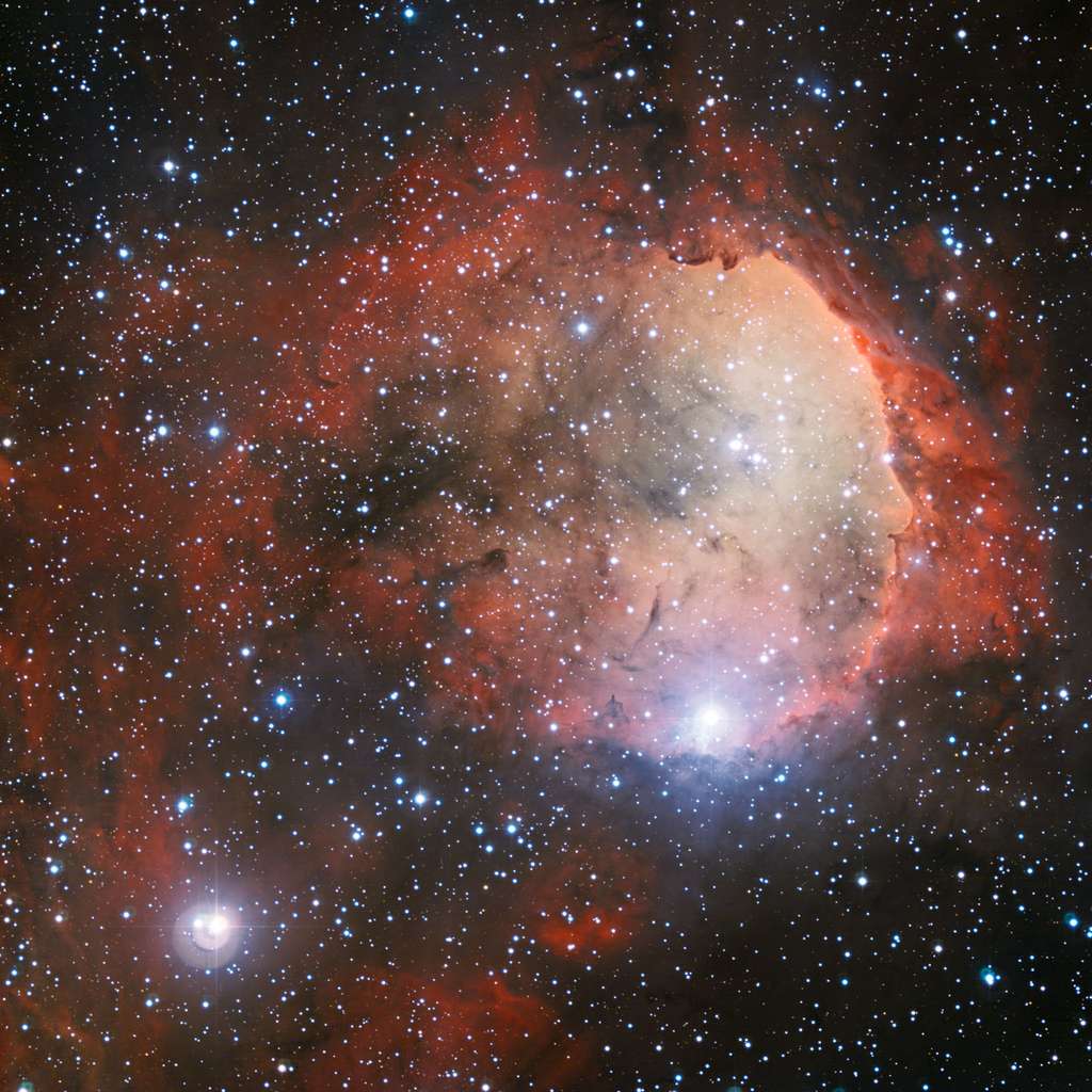Le rayonnement ultraviolet intense provenant de plusieurs jeunes étoiles chaudes de NGC 3324 fait briller le nuage de gaz avec de riches couleurs et a creusé une cavité dans la poussière et le gaz environnant. © ESO