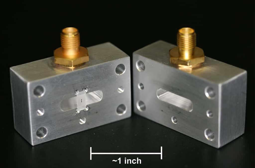 La cavité micro-onde en cuivre ouverte avec, en noir sur une surface translucide, le circuit supraconducteur portant un qubit. Un <em>inch</em> (pouce) vaut 2,54 cm. © IBM Research