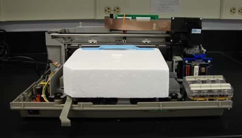 L'imprimante HP DeskJet 500 après les modifications. Elle peut désormais imprimer des cellules vivantes. Les fils orange (milieu et haut de la photo) sont utilisés pour court-circuiter le circuit d'alimentation de l'imprimante en papier. © Owczarczak <em>et al.</em> 2012, <em>Jove</em>