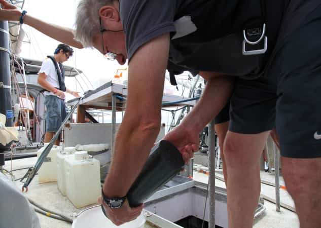 Gabriel Gorsky sur le pont en train de récupérer les micro-organismes planctoniques récoltés dans un collecteur. © S. d'Orgeval/Tara Expéditions