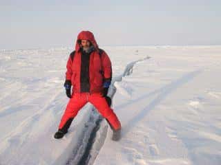 Julien Cabon à cheval entre deux plaques de glace. La banquise n'est qu'une pellicule glacée, de 1 à 2 mètres d'épaisseur, craquelée et perpétuellement en mouvement. © Pôle Nord 2012