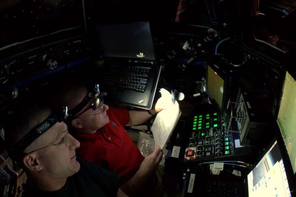 André Kuipers (à gauche) assiste Don Pettit pour agripper la capsule Dragon avec le bras <em>Mobile Servicing System</em> (MSS), alias Canadarm 2. © André Kuipers/Esa/Nasa