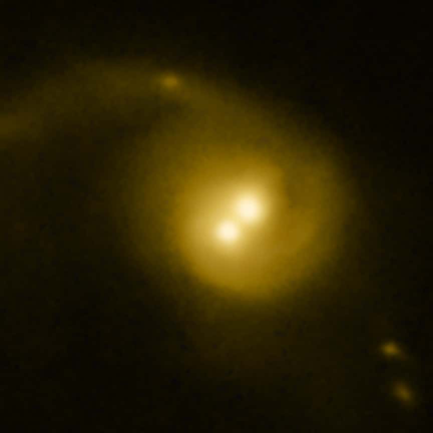 Observée dans le visible par Hubble, la galaxie présentant une source brillante en rayons X se révèle contenir deux zones brillantes comme si elle était formée de deux noyaux. Des observations plus précises de Chandra ont permis de découvrir que seule la région brillante dans le visible à gauche de la seconde était la source intense de rayons X. © Nasa