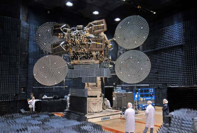 Le satellite EchoStar XVII installé dans une chambre anéchoïque (dont les parois absorbent fortement les ondes sonores) pour vérifier ses performances en radiofréquences et sa compatibilité électromagnétique. © Hughes