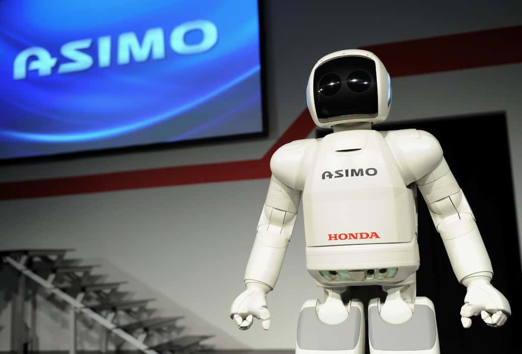 Le robot Asimo est un humanoïde très célèbre qui, à terme, pourrait aider les gens. Mais sa démarche est encore incertaine et il faudra encore l'équiper des nouvelles jambes biomécaniques pour qu'il ressemble davantage aux êtres humains. © Honda News, Fotopédia, cc by nc nd 2.0