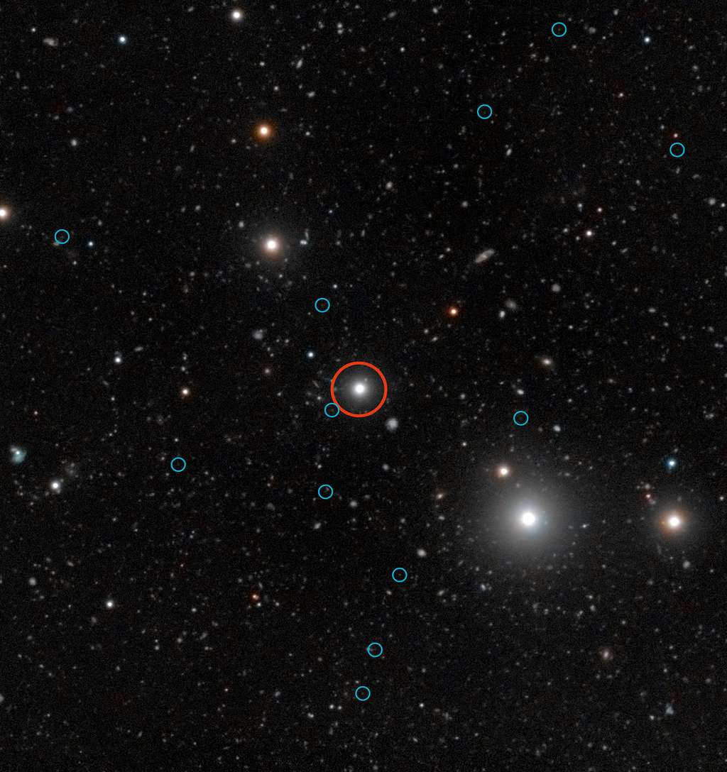 Cette image profonde montre une région du ciel autour du quasar HE0109-3518. Le quasar est repéré par un cercle rouge à proximité du centre de l'image. Le rayonnement énergétique du quasar fait briller les galaxies noires, aidant ainsi les astronomes à comprendre les phases primordiales obscures de la formation des galaxies. Les images faibles du rayonnement de 12 galaxies noires sont indiquées par des cercles bleus. Les galaxies noires sont pratiquement dénuées d'étoiles et, de ce fait, elles n'émettent aucune lumière que les télescopes peuvent capter. Elles sont ainsi pratiquement impossibles à observer à moins qu'elles ne soient illuminées par une source lumineuse extérieure comme un quasar en arrière-plan. Cette image combine des observations faites avec le VLT, dédiées à la détection d'émissions fluorescentes produites par un quasar illuminant les galaxies noires, avec des données couleur provenant du <em>Digitized Sky Survey 2</em>. © ESO, <em>Digitized Sky Survey 2</em>, S. Cantalupo (UCSC)