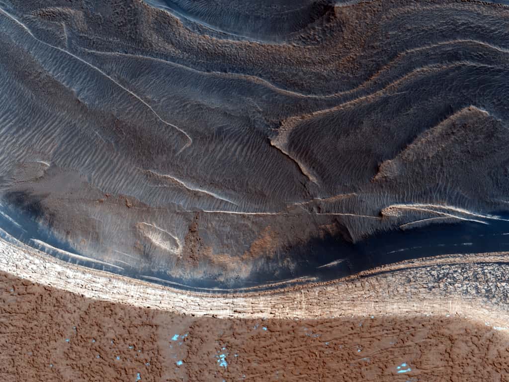 Des falaises de 800 m de haut bordent la calotte polaire nord qui atteint plusieurs kilomètres d'épaisseur au centre. Les internautes sont invités à rechercher la trace de rochers qui seraient tombés au pied de ces remparts. © Nasa/JPL/<em>University of Arizona </em>