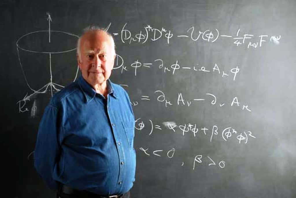 Peter Higgs devant les équations décrivant sa théorie de la brisure de symétrie donnant une masse à des bosons de jauge. Le champ de Higgs donne aussi une masse aux quarks et leptons mais pas aux protons et neutrons. © Peter Tuffy, The University of Edinburgh