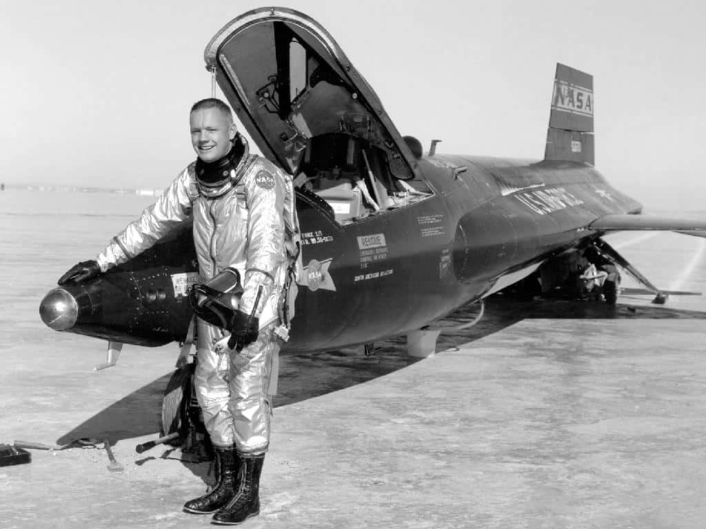 Neil Armstrong à côté d'un des avions-fusées X-15 qu'il a pilotés. Le <em>North American X-15</em> était un avion-fusée expérimental américain, construit dans le cadre d'un programme de recherche sur les vols à très haute vitesse et très haute altitude. © Nasa